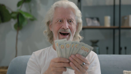 Portrait of Old Man Counting Money at Homeの写真素材