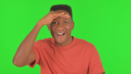 Portrait of African Man Searching New Opportunity on Green Backgroundの写真素材