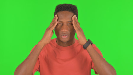 Portrait of African Man with Migraine on Green Backgroundの写真素材