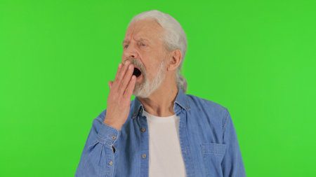 Portrait of Yawning Senior Old Man on Green Backgroundの写真素材