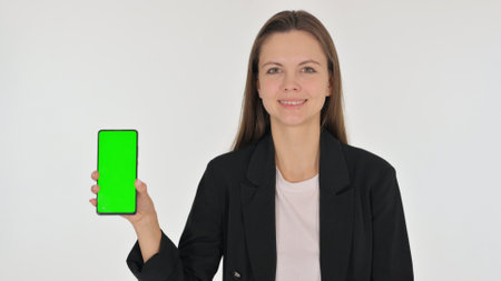 Casual Young Woman Showing Smartphone with Green Screen on white Backgroundの写真素材