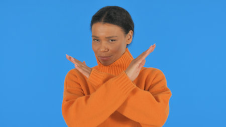 Tense Casual African Woman in Denial on Blue Background, Portraitの写真素材