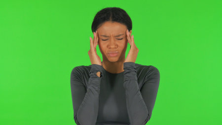 African Woman with Headache on Green Backgroundの写真素材