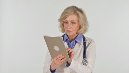 Portrait of Senior Female Doctor Using Digital Tablet on White Backgroundの写真素材