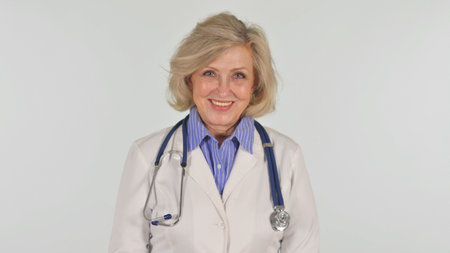Portrait of Smiling Senior Female Doctor on White Backgroundの写真素材