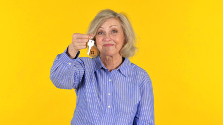 Happy Old Woman Showing Home Keys on White Backgroundの写真素材