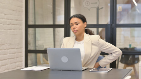 African Business Woman having Back Fatigue and Pain in Officeの写真素材