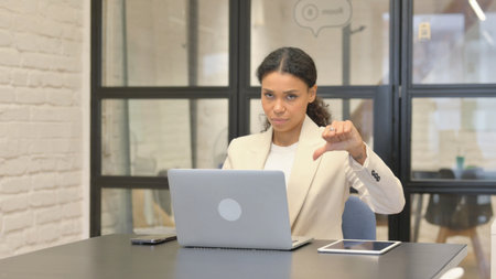 Thumbs Down by African Business Woman Using Laptopの写真素材