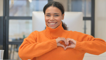Portrait of African Woman Making a Heart with Handsの写真素材