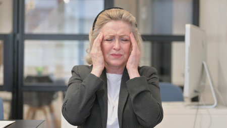 Portrait of Senior Old Business Woman with Headache in Office