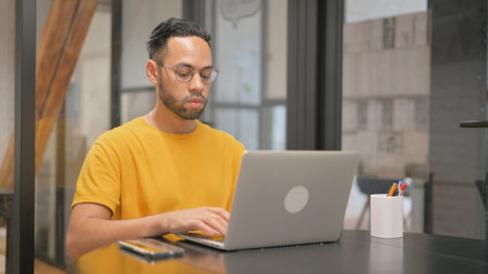Creative Mixed Race Man Typing on Laptopの写真素材