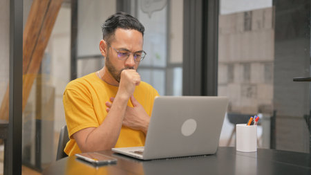 Creative Mixed Race Man having Cough at Work