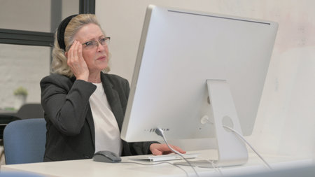 Senior Old Business Woman having Headache at Workの写真素材