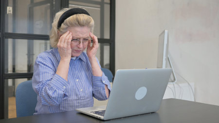 Casual Old Woman having Headache at Workの写真素材