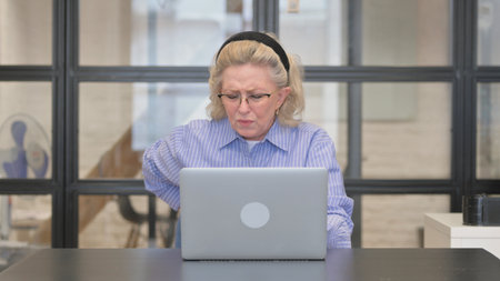 Casual Old Woman having Back Fatigue and Pain in Officeの写真素材