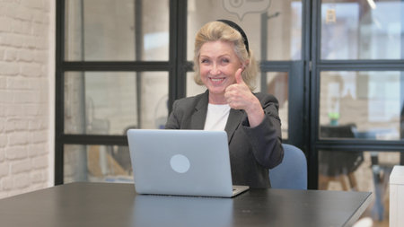 Thumbs Up by Senior Old Business Woman Using Laptopの写真素材