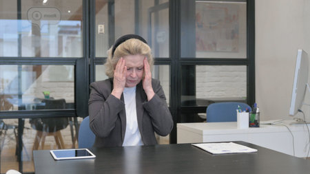 Senior Old Business Woman with Headache in Officeの写真素材