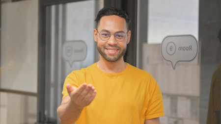 Portrait of Confident Casual Young African Man inviting Peopleの写真素材