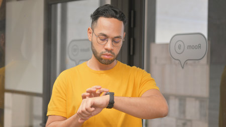 Casual Young African Man Using Smart Watchの写真素材