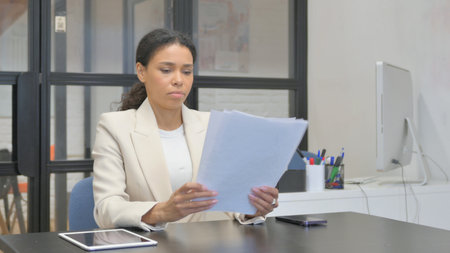 African Business Woman Reading Documents at Workの写真素材