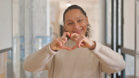 Portrait of a beautiful middle-aged woman making a heart with her hands