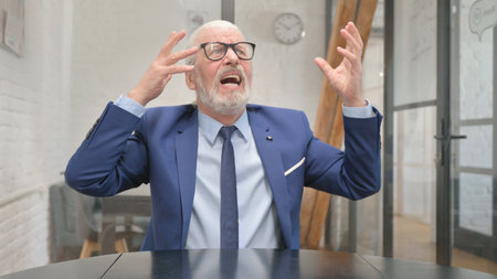 Frustrated Senior Old Businessman Feeling Angry and Tense at Workplaceの写真素材