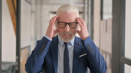Portrait of Old Businessman with Headache in Officeの写真素材