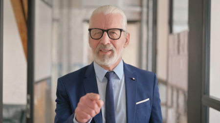 Portrait of Old Businessman Pointing at Camera