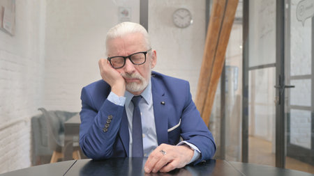 Tired Senior Old Businessman Sleeping at Workplaceの写真素材