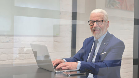 Smiling Old Businessman Looking at Camera in Officeの写真素材