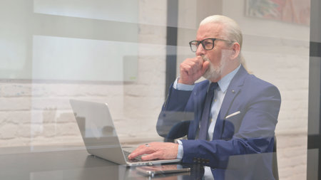 Sick Senior Businessman Coughing at Workplace