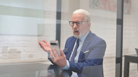 Senior Businessman with Trading Loss on Phone at Workplace