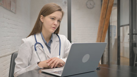 Young Female Doctor Talking with Patient Onlineの写真素材
