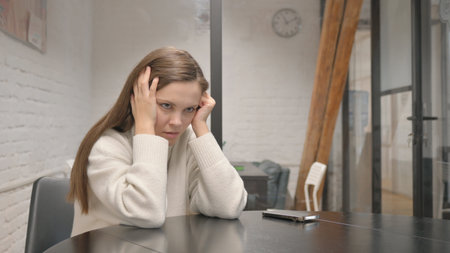 Tense Young Woman Feeling Angry and Uncertain at Workspaceの写真素材