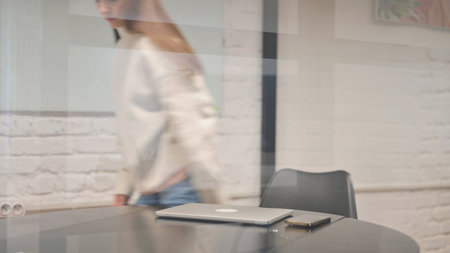 Young Woman Leaving Workspace after Closing Laptopの写真素材