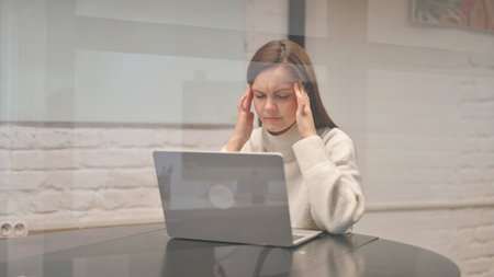Young Woman with Migraine at Workspaceの写真素材