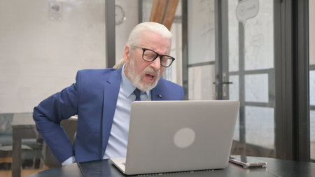 Senior Old Businessman having Back Fatigue and Pain at Workplaceの写真素材