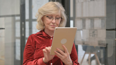 Portrait of Senior Old Woman Working on Digital Tablet