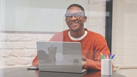 Excited African Man Smiling at Camera at Workspace