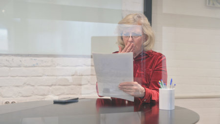 Shocked Senior Old Woman Reacting to New Loss Reportの写真素材