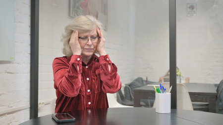 Tense Senior Adult Woman with Pain in Headの写真素材