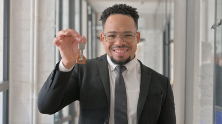 Portrait of Happy Hispanic Businessman Showing Home Keysの写真素材