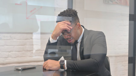 Tense Hispanic Man with Migraine at Work