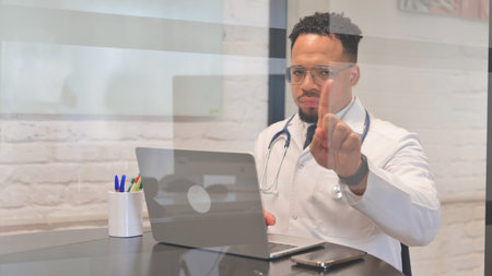 Displeased Multiracial Male Doctor Denying while Looking at Cameraの写真素材