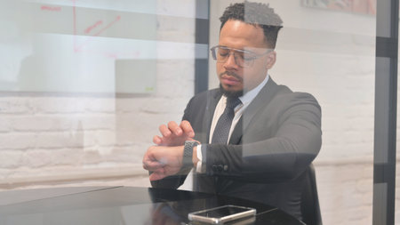 Hispanic Businessman Answering Message with Smart Watch