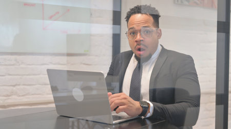 Shocked Hispanic Businessman while Looking at Camera
