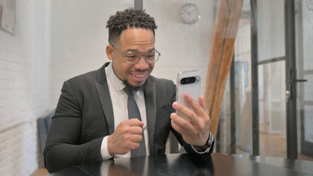 Multiracial Businessman Excited for Online Successful Trade on Phoneの写真素材