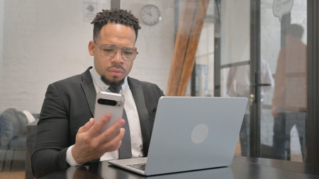 Multiracial Businessman Using Multiple Digital Devices for Workの写真素材