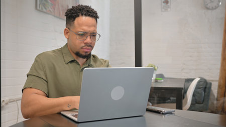 Mature Adult Hispanic Man Typing on Laptopの写真素材