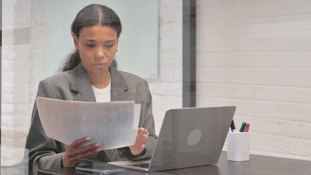 Paperwork and Using Laptop, Busy African Businesswoman